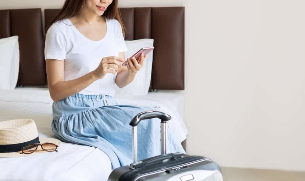 A girl sits on a sofa in a hotel and looks at her phone