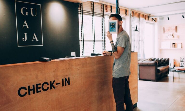 A man stands at the front desk of a hotel